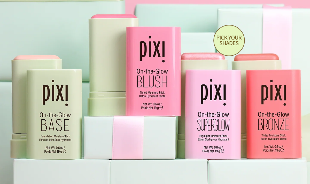 A set of Pixi On-the-Glow moisturizing sticks and blush in pastel packaging, including Base, Blush, SuperGlow, and Bronze shades, arranged on white blocks against a pastel background.