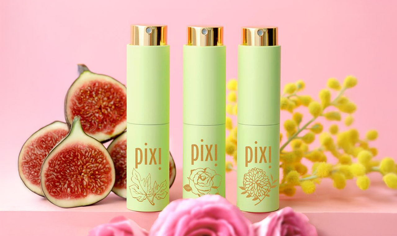 PixiPerfume Trio shown on a pink background with figs, mimosa, and roses