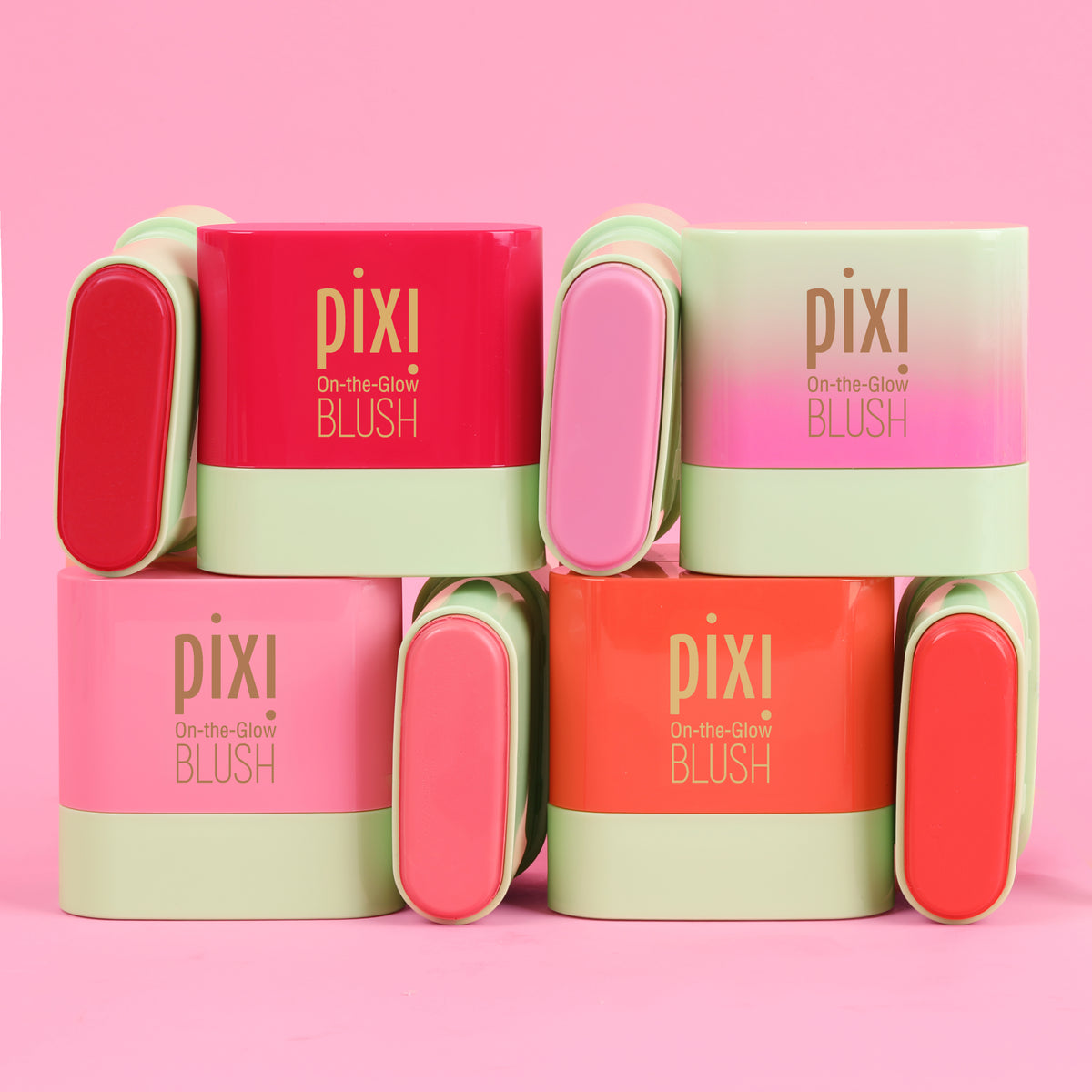 Pixi On-the-Glow Blush Petites in assorted vibrant shades including red, coral, and pink, arranged in a neat 2x3 grid on a solid pink background.