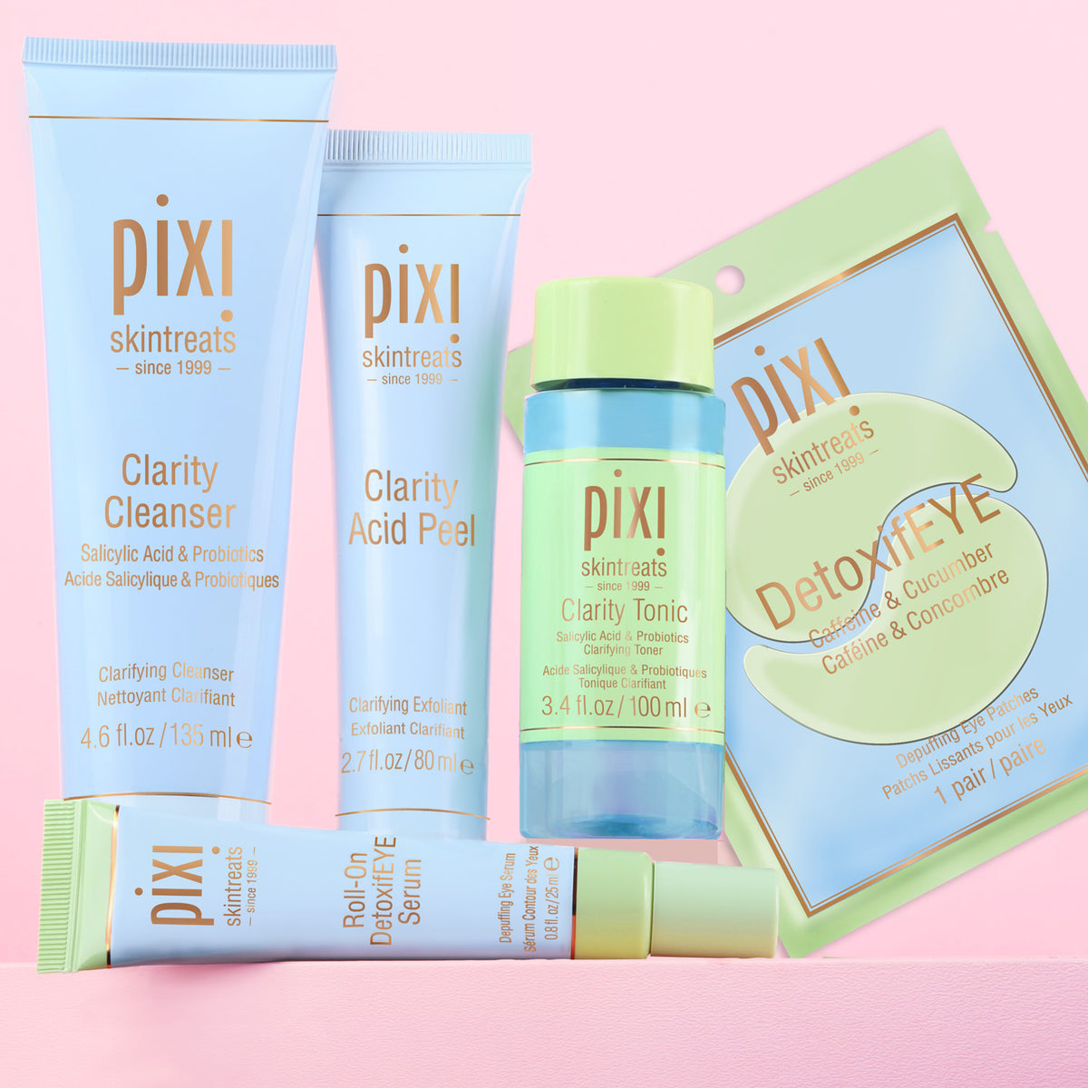 Clear Skin Reset Bundle shown on a pink background featuring Clarity Cleanser, Clarity Acid Peel, Clarity Tonic, Roll-On DetoxifEYE Serum and DetoxifEYE pair of patches -